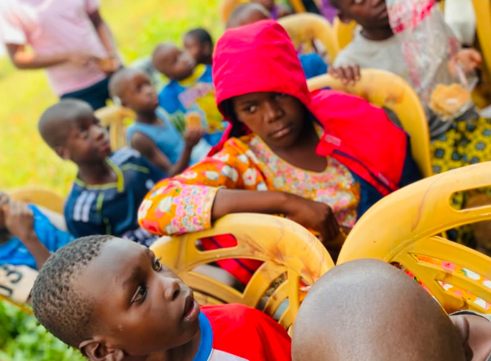 A young girl in a red hood looking at the camera
